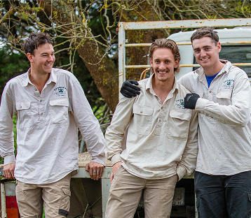 Three Yeowarra team members smiling and standing together behind a white truck.